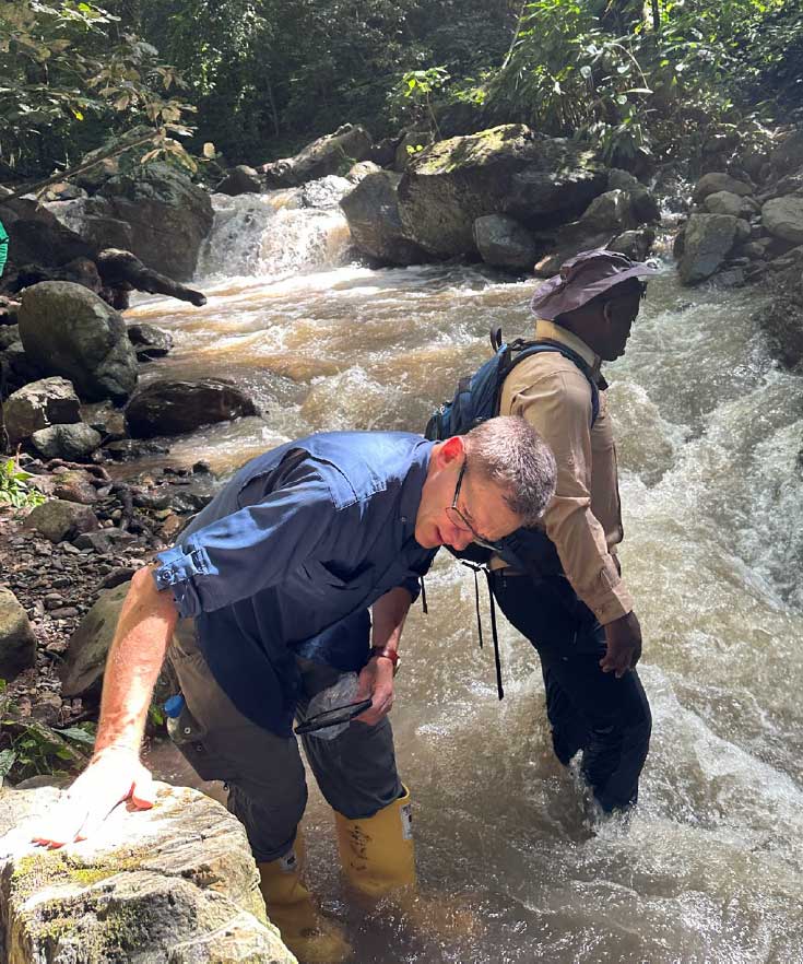 Mac Canby examines the geology in a stream at the Sierra Azul project in Colombia.